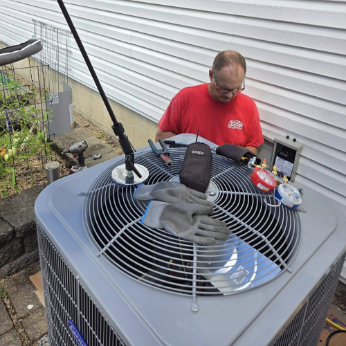 hvac tech doing maintenance to a unit outdoor